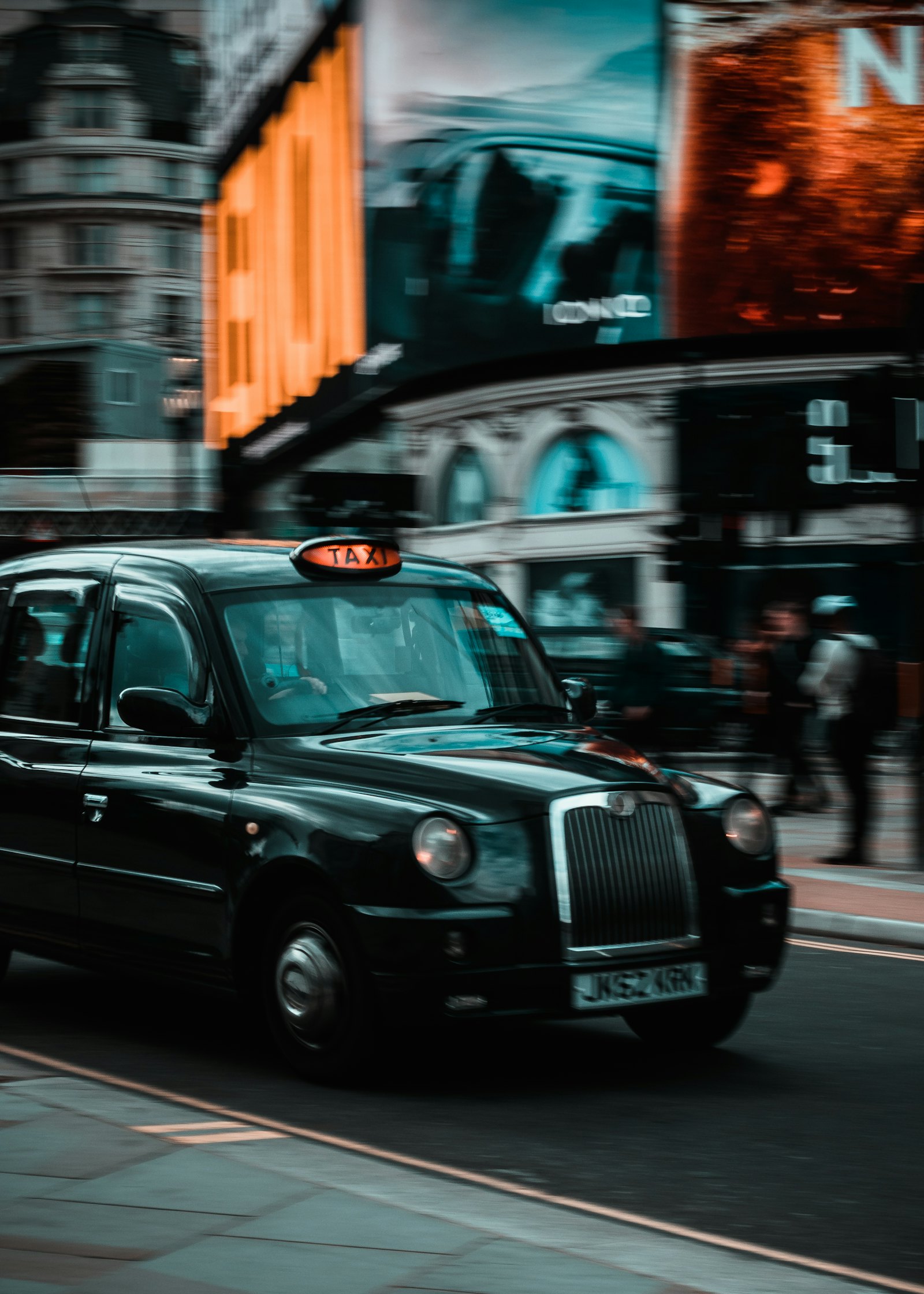 Licensed black taxi with an illuminated roof sign waiting on a British street
